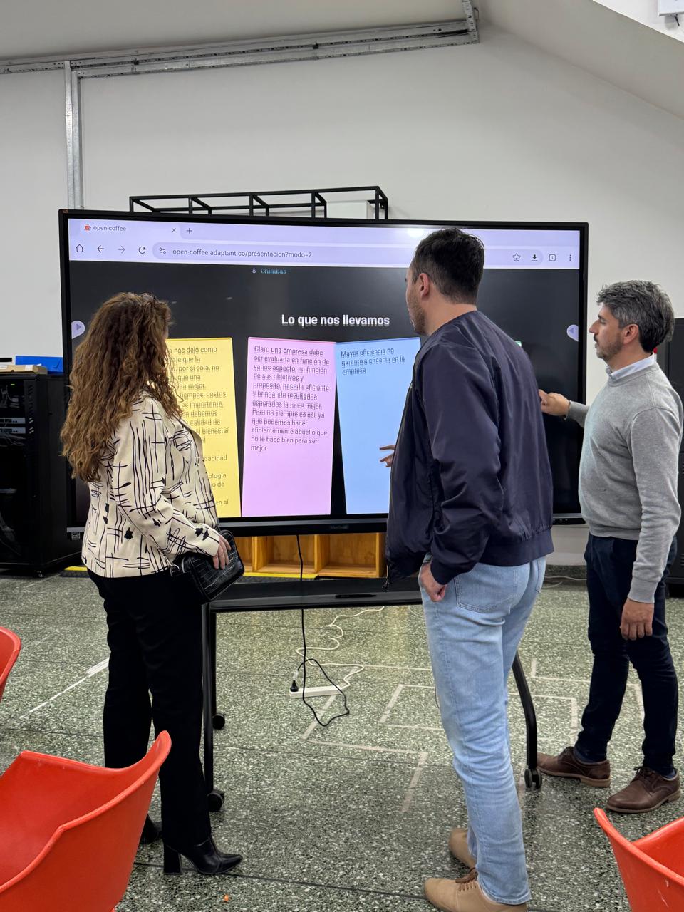 Tres personas revisando juntas los resultados proyectados al final del evento